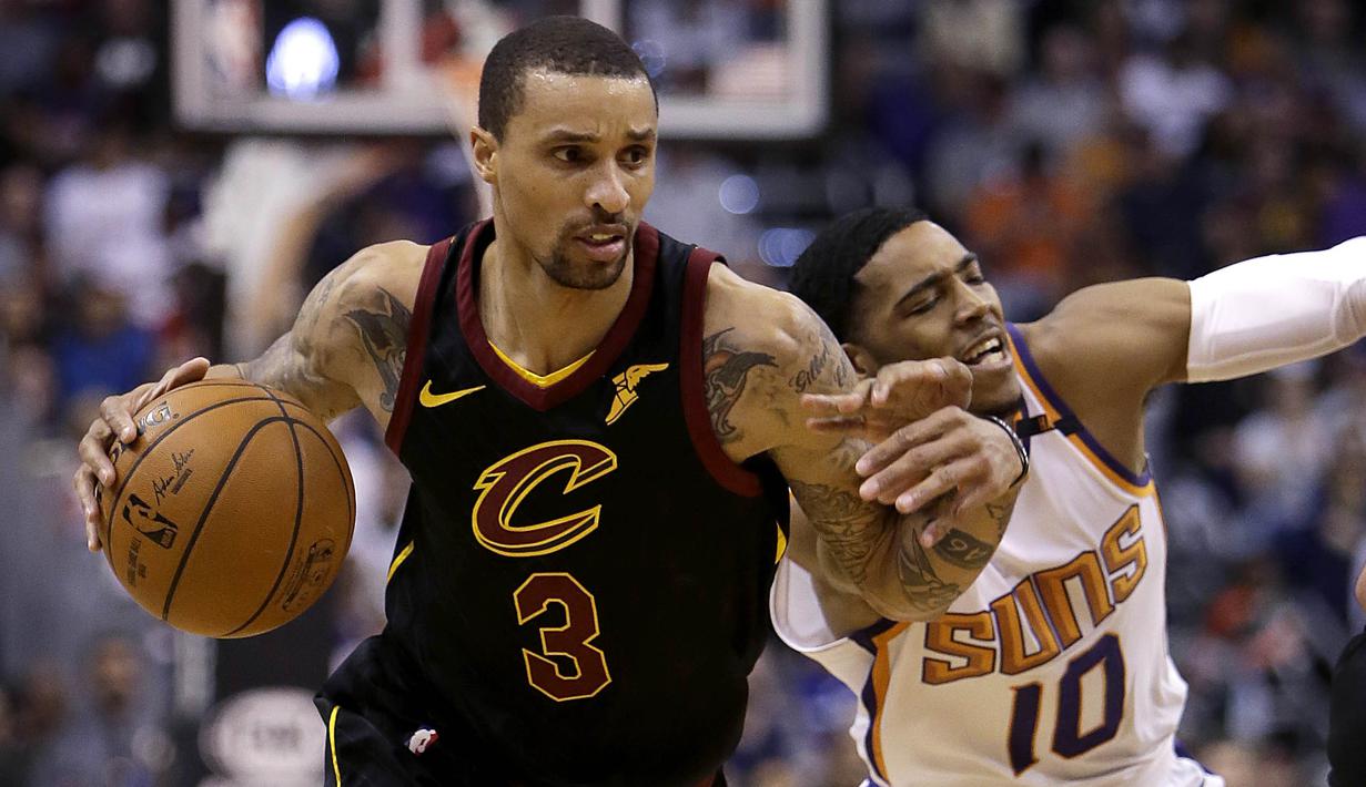 Pebasket Cleveland Cavaliers, George Hill, berusaha melewati pebasket Phoenix Suns, Shaquille Harrison, pada laga NBA di Talking Stick Resort Arena, Rabu (14/3/2018). Cleveland Cavaliers menang 129-107 atas Phoenix Suns. (AP/Rick Scuteri)