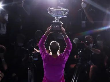 Petenis asal Spanyol, Rafael Nadal sukses mengunci gelar ke-21 grand slamnya usai mengalahkan petenis nomor dua dunia, Daniil Medvedev di laga final Australia Open 2022, Minggu (30/01/2022). (AFP/Brandon Malone)