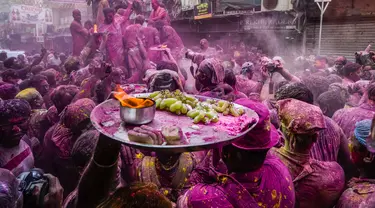 Umat Hindu dengan persembahan berjalan menuju mobil yang membawa patung dewa Krishna selama festival Holi di Kolkata, India, Minggu, 5 Maret 2023. Holi atau Festival Warna adalah festival awal musim semi yang dirayakan di India, Nepal, Bangladesh, dan negara-negara berikut yang memiliki penduduk beragama Hindu. (AP Photo/Bikas Das)