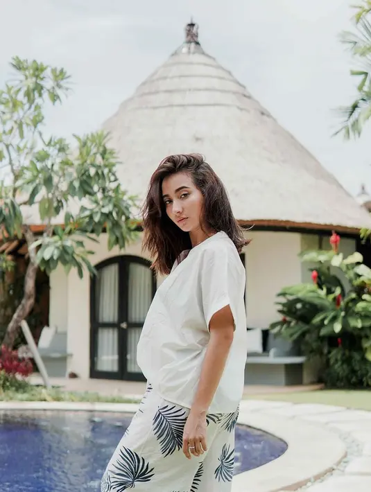 Tampil simpel dengan atasan warna putih dan kulot pattern daun. Pilih model yang simpel dan tidak terlalu ramai justru membuat kesan elegan dan anggun. Gaya liburan Naomi ini bisa jadi inspirasi gaya liburan untuk anak muda.(Liputan6.com/IG/@naonomnom)