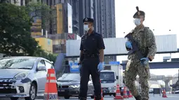Polisi memeriksa penumpang di kendaraan di penghalang jalan pada hari pertama Perintah Kontrol Gerakan Penuh (MCO) di Kuala Lumpur, Malaysia, Selasa (1/6/2021). Mal dan sebagian besar bisnis di Malaysia tutup pada Selasa karena negara itu memulai penguncian total kedua . (AP Photo/Vincent Thian)