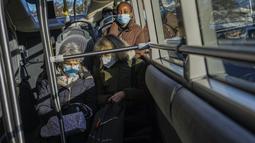 Orang-orang yang memakai masker untuk melindungi diri dari COVID-19 naik bus di Versailles, barat Paris (11/1/2022). Pada pertengahan Januari, pemerintah Prancis berharap untuk memperkenalkan izin vaksin yang akan mewajibkan vaksinasi untuk siapa pun yang ingin pergi. (AP Photo/Michel Euler)