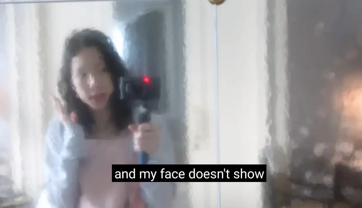 Taeyeon terbangun di hotel dengan menajak penggemar menebak-nebak, sedang ada di mana dia? Pelantun lagu "I" ini juga mengagumi kaga yang ada di kamar hotelnya. Katanya, cermin yang membuat refleksi wajah buram sangat bagus untuk menyamarkan wajah bangun tidurnya. (Foto: YouTube/ Taeyeon Official)