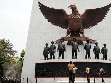 Sejumlah Pramuka mengabadikan patung tujuh pahlawan revolusi di Monumen Pancasila Sakti, Jakarta, Selasa (29/9/2015). Pemerintah akan mengadakan upacara peringatan Hari Kesaktian Pancasila pada 1 Oktober mendatang. (Liputan6.com/Helmi Fithriansyah)