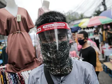 Pedagang menggunakan alat pelindung wajah (Face Shield) saat berjualan di Kawasan Tanah Abang, Jakarta, Senin (18/5/2020). Penggunaan alat pelindung wajah itu sebagai upaya untuk melindungi diri saat berhubungan dengan pembeli dalam pecegahan penyebaran COVID-19. (Liputan6.com/Faizal Fanani)