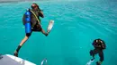 Instruktur selam Arab Saudi, Nouf Alosaimi bersama instruktur selam Mesir, Tamer Nasr melompat ke Laut Merah dekat King Abdullah Economic City. Pesona keindahan Laut Merah memikat pengunjung dari seluruh dunia. (AP Photo/Amr Nabil)