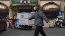 Seorang pria dengan masker berjalan di dekat sebuah restoran di Beijing,  China, Jumat (2/12/2022). Lebih banyak kota melonggarkan pembatasan, memungkinkan pusat perbelanjaan, supermarket, dan bisnis lainnya dibuka kembali menyusul protes akhir pekan lalu di Shanghai dan daerah lain di mana beberapa orang menyerukan Presiden Xi Jinping untuk mengundurkan diri. (AP Photo/Ng Han Guan)