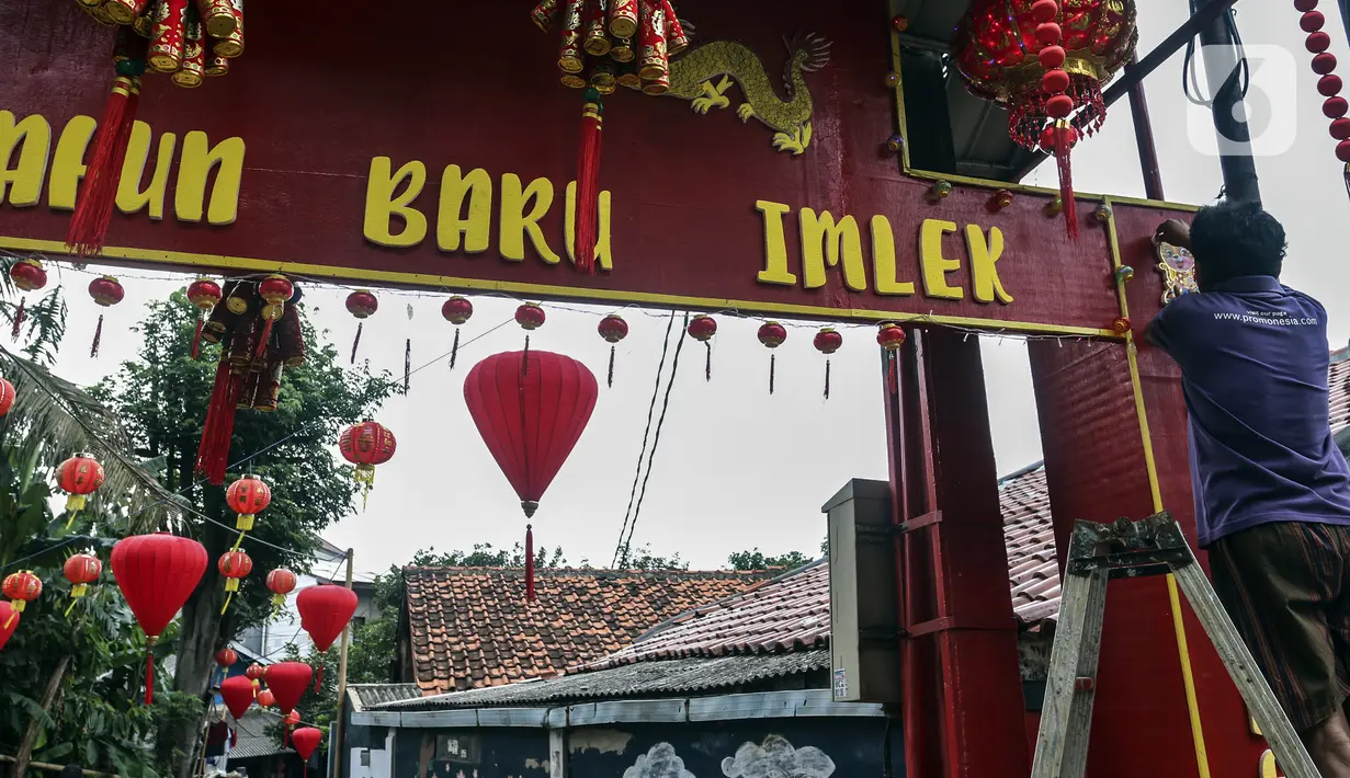 Warga menghias gapura dengan pernak-pernik Imlek di Kampung Limo, Depok, Jawa Barat, Rabu (26/1/2022). Kampung dengan sejumlah warga keturunan Tionghoa tersebut menyambut perayaan Tahun Baru Imlek 2022 dengan menghias gapura dan jalan dengan pernak-pernik Imlek. (Liputan6.com/Johan Tallo)