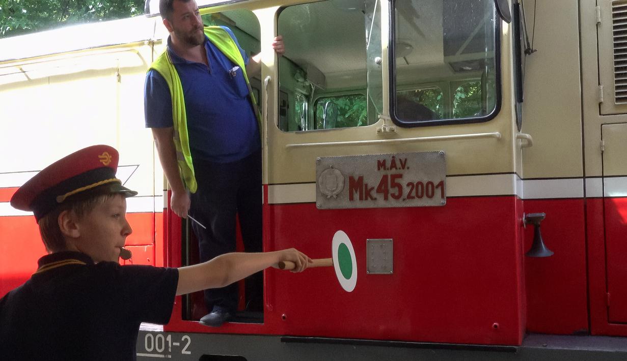 Seorang anak bekerja di Stasiun Kereta Anak Huvosvolgy di Budapest, Hungaria pada 26 Agustus 2020. Di bawah pengawasan orang dewasa, anak-anak itu bertanggung jawab mengoperasikan sakelar jalur dan sinyal, mencetak tiket, dan memberikan informasi kepada penumpang. (Xinhua/Attila Volgyi)