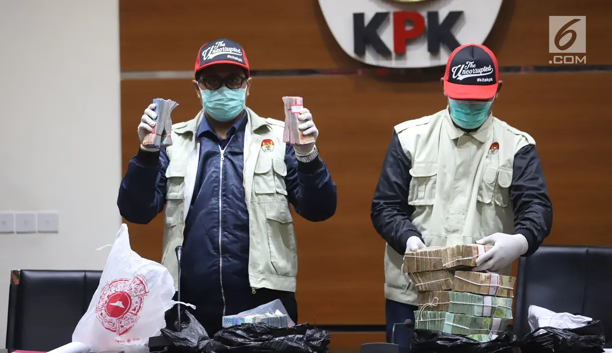 Petugas KPK menunjukkan barang bukti uang saat jumpa pers terkait OTT Bupati Cirebon Sunjaya Purwadi Sastra di Gedung KPK, Jakarta, Kamis (25/10). KPK menetapkan Sunjaya sebagai tersangka suap jual beli jabatan. (Liputan6.com/Herman Zakharia)