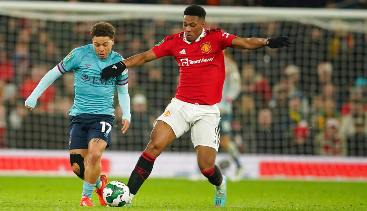 Pemain Manchester United Anthony Martial berebut bola dengan pemain Burnley Manuel Benson pada pertandingan sepak bola putaran keempat Piala Liga Inggris di Old Trafford, Manchester, Inggris, 21 Desember 2022. (AP Photo/Dave Thompson)