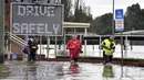 Warga mengarungi banjir yang meningkat di pinggiran barat daya Camden, Sydney, Australia, Selasa (8/3/2022). (Muhammad FAROOQ/AFP)