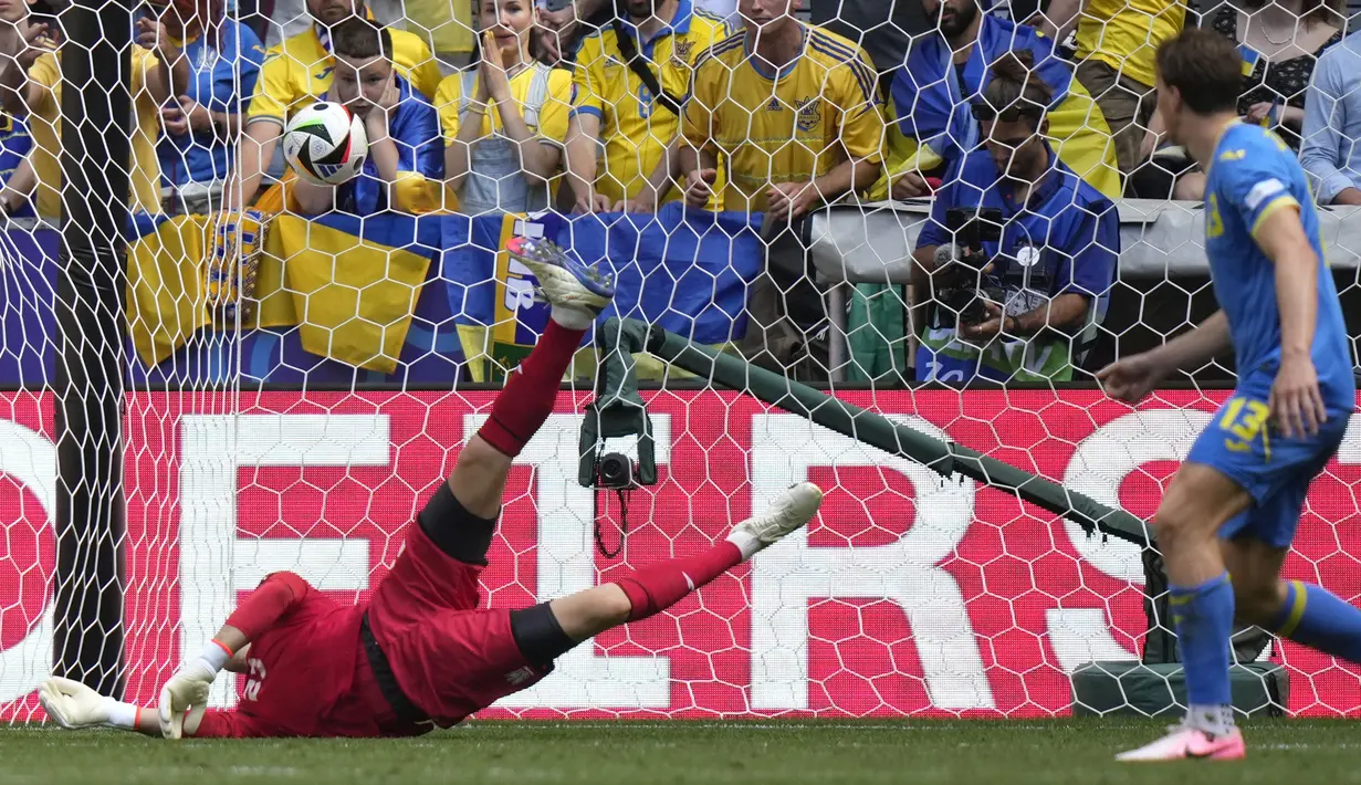 Kiper Timnas Ukraina, Andriy Lunin kebobolan gol kedua saat menghadapi Rumania tewat tendangan dari luar kotak penalti Razvan Marin pada laga Grup E Euro 2024 di Allianz Arena, Munchen, Jerman, Senin (17/6/2024). (AP Photo/Matthias Schrader)