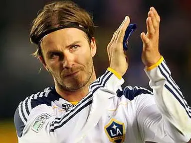 Gelandang LA Galaxy David Beckham memberi sambutan ke arah fans pada lanjutan Major League Soccer melawan DC United di Carson, California. Victor Decolongon/Getty Images/AFP