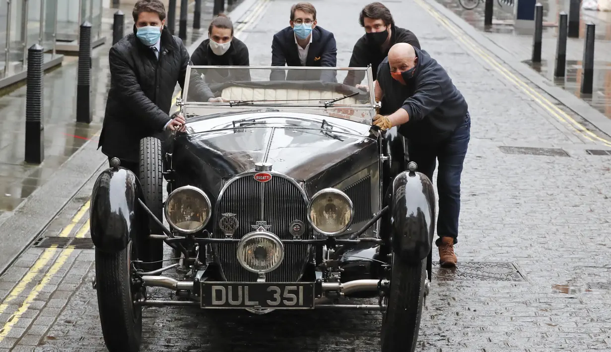 Staf mendorong Bugatti Type 57S 1937, salah satu mobil pra-perang paling diinginkan di dunia, di luar rumah lelang Bonhams,  London, Selasa (16/2/2021). Bugatti ini telah tersembunyi selama 50 tahun terakhir dan merupakan salah satu dari 42 contoh varian 57S yang diproduksi (AP Photo/Frank Augstein)