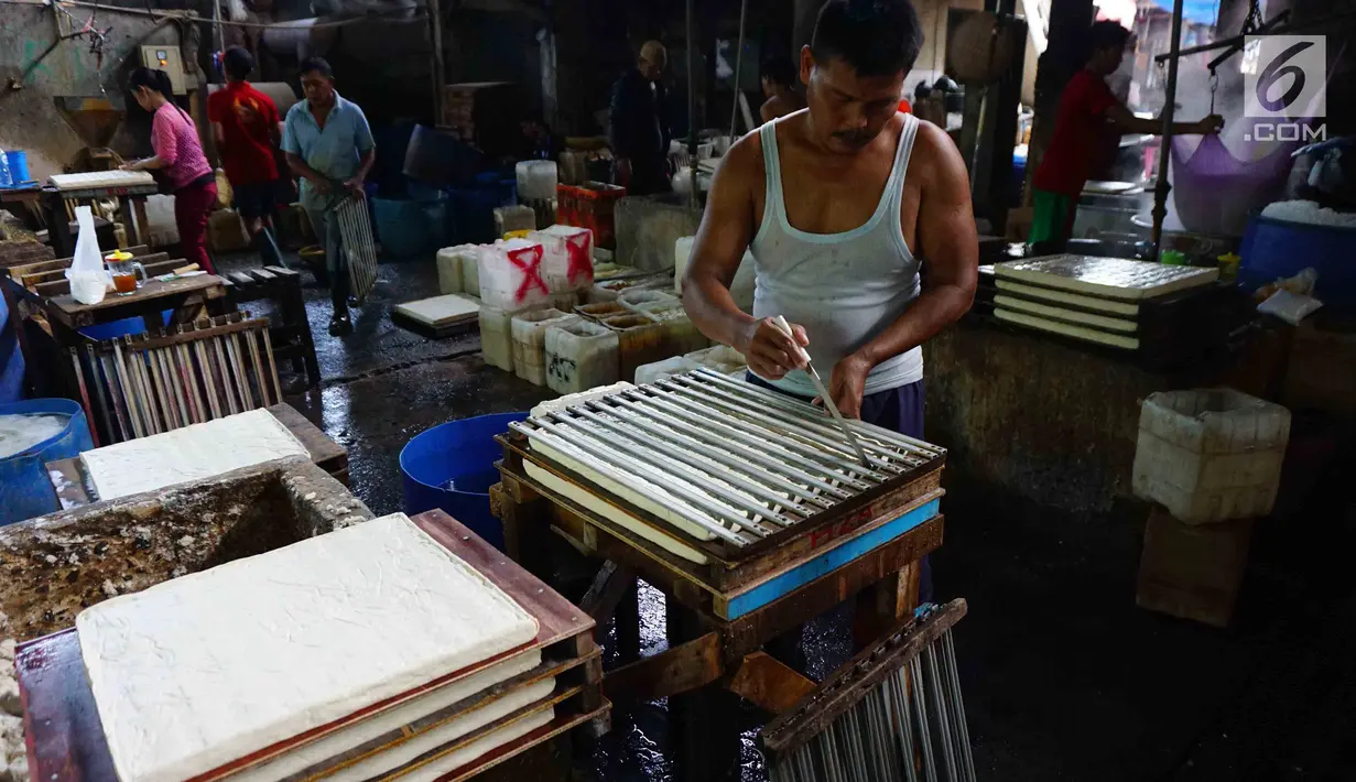 Pekerja memotong adonan tahu di industri rumahan di Jakarta, Senin (22/1). Selain itu, target penyaluran KUR dinaikan menjadi Rp 120 triliun pada 2018. (Liputan6.com/Angga Yuniar)