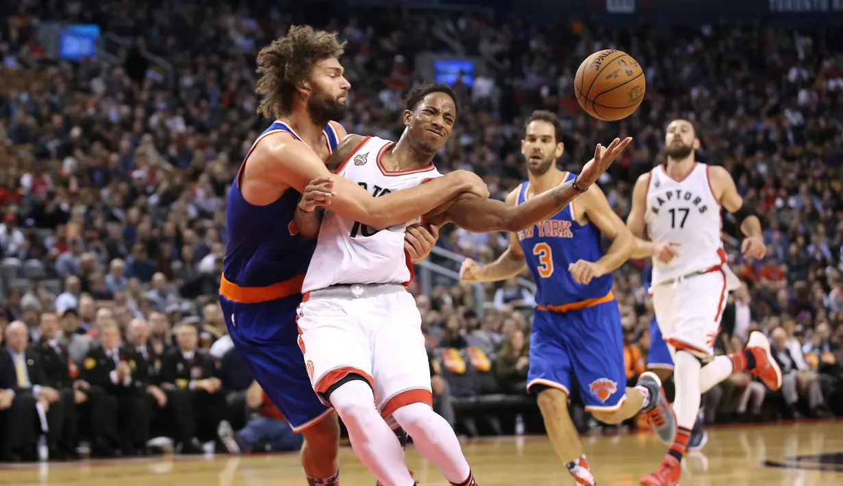 Pebasket Toronto Raptors  DeMar DeRozan (kanan) berebut bola dengan pebasket New York Knicks Robin Lopez  pada lanjutan NBA di Air Canada Centre, Toronto, Rabu(11/11/2015) WIB. Knicks kalahkan Raptors 111-109. (Reuters/Tom Szczerbowski-USA TODAY Sports)
