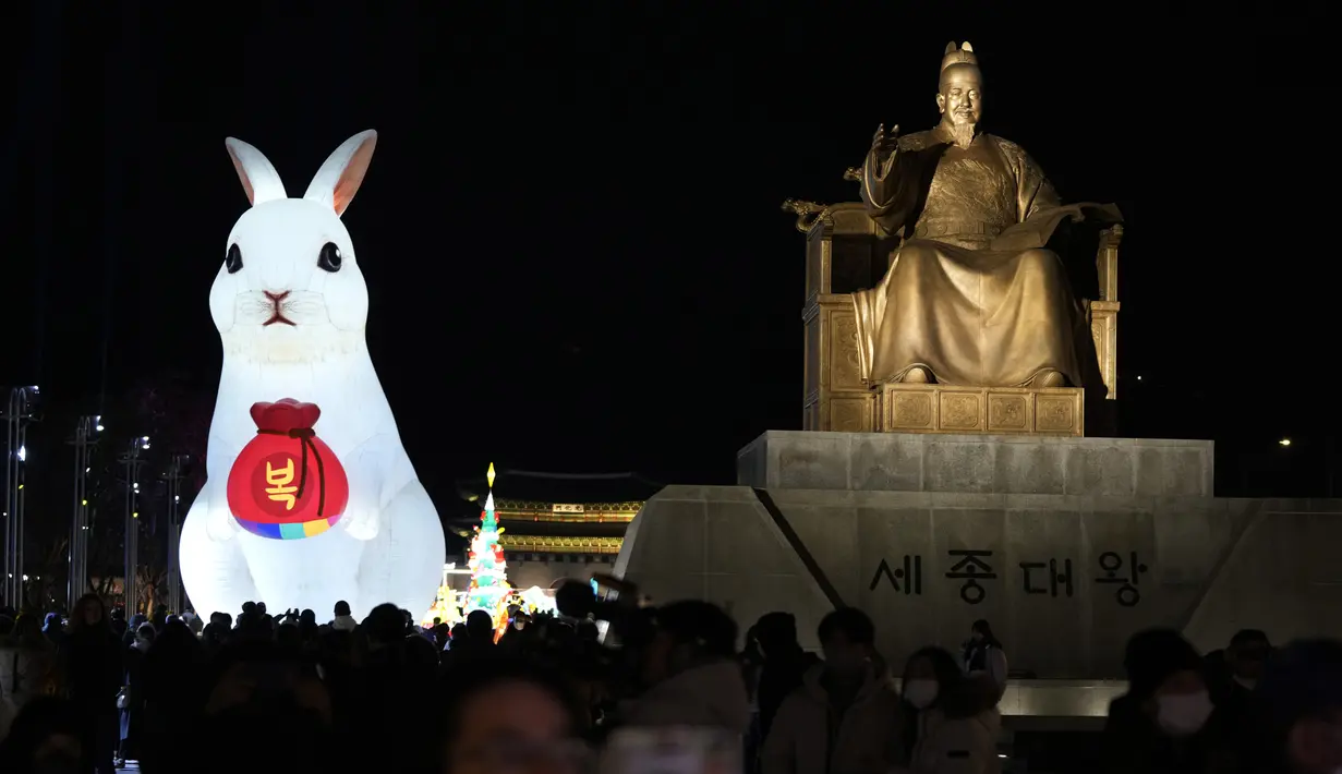 Lentera raksasa yang bersinar di sebelah patung Raja Sejong dari Dinasti Joseon selama perayaan Tahun Kelinci 2023 mendatang di Lapangan Gwanghwamun, Seoul, Korea Selatan, Senin (19/12/2022). Festival Lentera ini akan berlangsung dari 19-31 Desember 2022. (AP Photo/Ahn Young-joon)