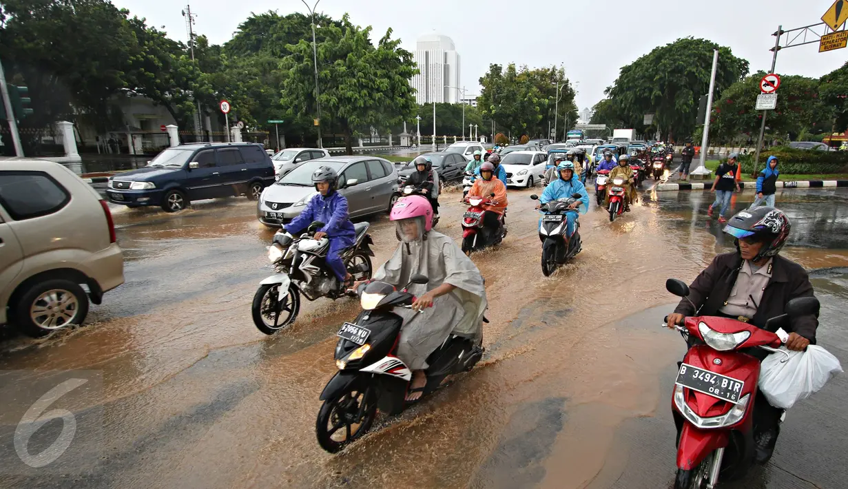 Sejumlah kendaraan melaju melewati genangan air hujan yang merendam jalan di depan Istana Merdeka, Jakarta, Selasa (9/2). Hujan deras yang mengguyur kota Jakarta membuat sejumlah jalan protokol tergenang air. (Liputan6.com/Immanuel Antonius)