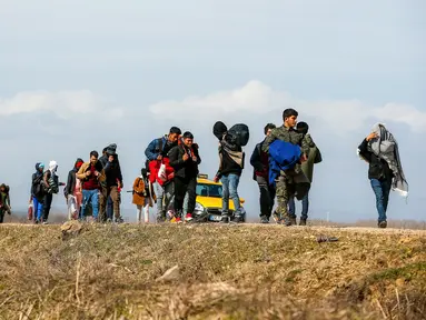 Para migran berjalan menuju gerbang perbatasan Turki dengan Yunani di Ipsala, Edirne, Turki, Selasa (3/3/2020). Ribuan migran dan pengungsi dari Turki dilaporkan berusaha untuk menemukan jalan melintasi perbatasan darat ke Yunani. (AP Photo/Emrah Gurel)