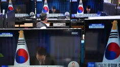 Seorang penjaga toko menyaksikan layar televisi yang menampilkan siaran langsung Presiden Korea Selatan Yoon Suk Yeol yang membungkuk setelah mengakhiri pidatonya, di sebuah pasar elektronik di Seoul pada Sabtu 7 Desember 2024. (Jung Yeon-je/AFP)