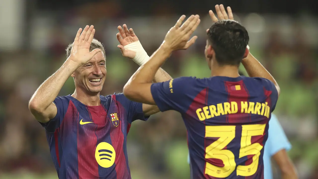 Robert Lewandowski dari Barcelona merayakan gol bersama rekannya, Gerard Martin