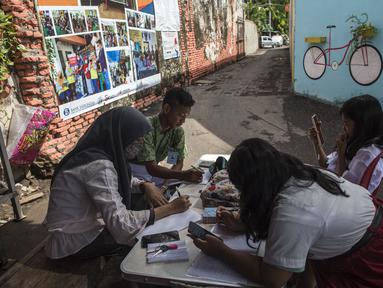 Siswa menggunakan gawai untuk mengikuti kegiatan belajar mengajar secara daring di tempat pembuangan sampah yang menyediakan WiFi gratis, di Surabaya, Rabu (15/9/2021). Belajar secara virtual itu sudah berjalan lebih dari setahun lebih di tengah pandemi Covid-19. (JUNI KRISWANTO/AFP)