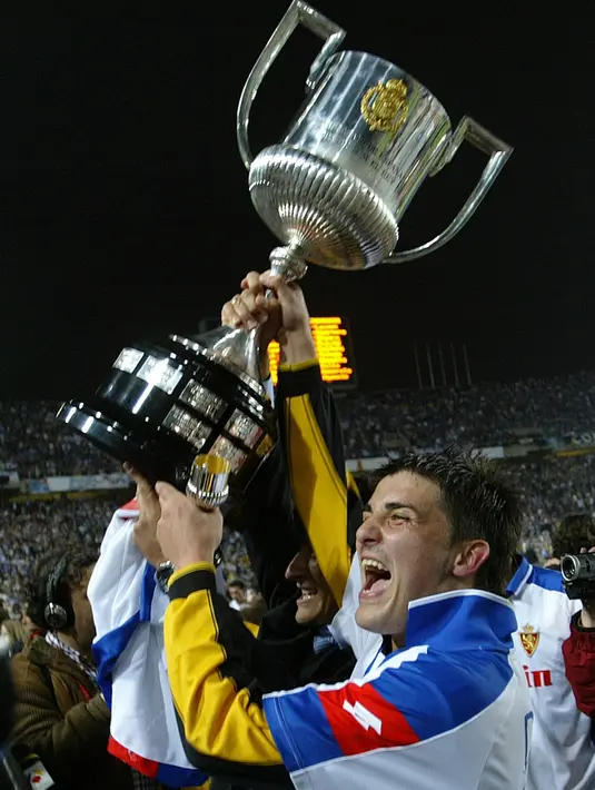 Foto pemain depan Real Zaragoza, David Villa  mengangkat Piala Raja setelah bertanding melawan Real Madrid di Stadion Olimpiade, Barcelona 17 Maret 2004. Di klub ini, Villa berhasil mencetak 17 gol di musim pertamanya dan mempersembahkan trofi Copa del Rey 2004. (AFP/Lluis Gene)