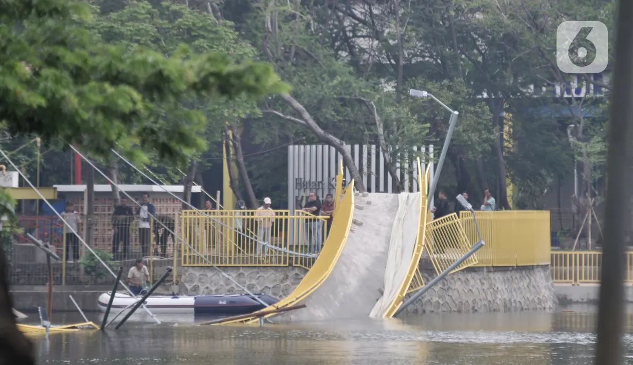 Pihak PPK Kemayoran memeriksa jembatan ambruk di Hutan Kota Kemayoran, Jakarta, Minggu (22/12/2019). Beruntung tidak ada korban jiwa dalam kejadian tersebut, namun saat kejadian ada beberapa pekerja tengah melakukan finishing jembatan tercebur ke danau. (Merdeka.com/Iqbal S. Nugroho)