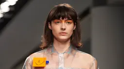Seorang model berjalan di catwalk mengenakan busana unik label Fyodor Golan edisi Fall/Winter 2017 selama London Fashion Week di London, 17 Februari 2017. Terlihat kertas post-it ditempel pada outerwear transparan berpotongan jaket. (NIKLAS HALLE'N/AFP)