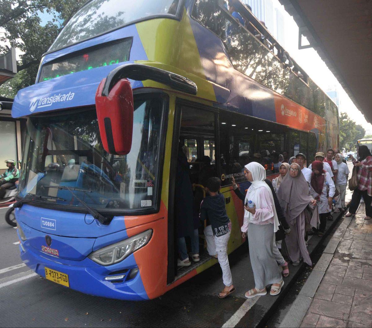 Sejumlah warga mengantre untuk menaiki bus wisata atap terbuka di&nbsp;Jakarta, Jumat (21/6/2024). Bus wisata atap terbuka menjadi wisata alternatif bagi sebagian warga Jakarta untuk menikmati liburan, terlebih ketika memasuki masa libur sekolah seperti s