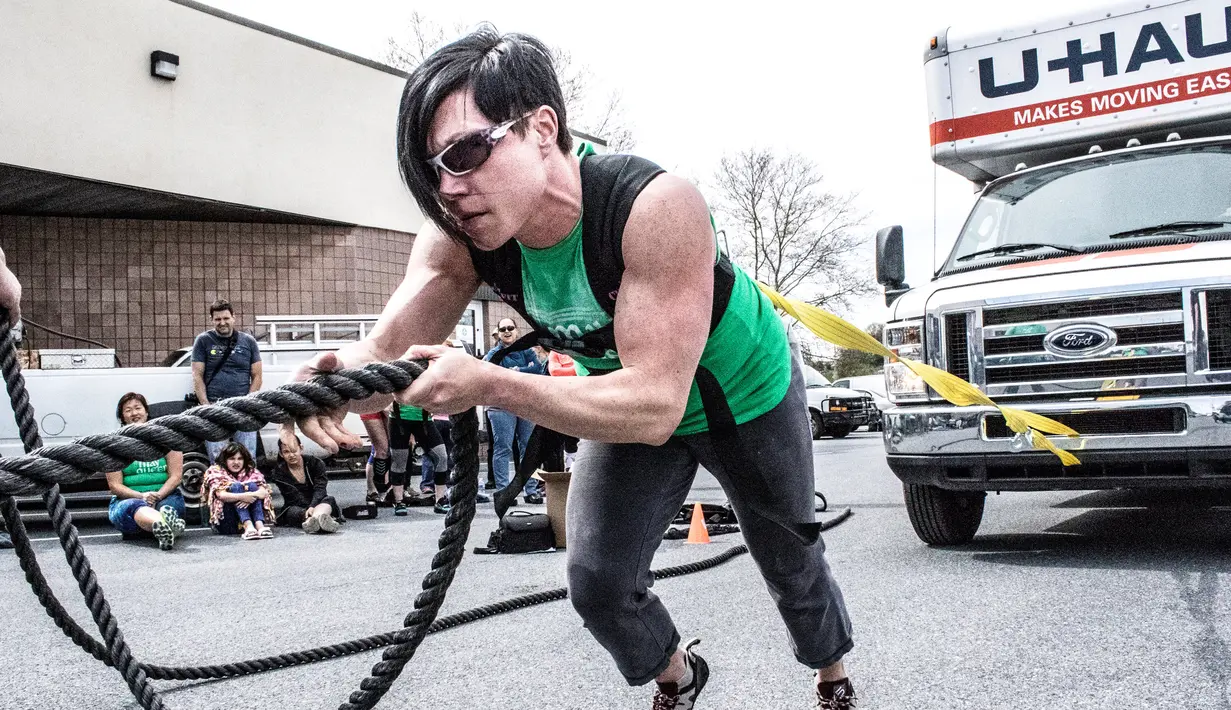 Seorang wanita menarik truk dengan tubuhnya saat kompetisi May Queen Spring Strongwoman di Lancaster, Pennsylvania, AS (25/4). Kegiatan tersebut untuk memperingati Hari Ibu. (Reuters)