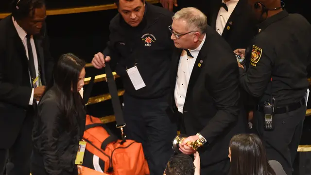 Rami Malek saat diperiksa paramedis karena terjatuh di panggung Oscar 2019. (Photo by Chris Pizzello/Invision/AP)