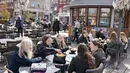 Orang-orang duduk di luar restoran untuk layanan luar ruangan di Roskilde Denmark, pada Rabu (21/4/2021). Denmark mengizinkan diberlakukannya layanan indoor di restoran dan kafe mulai 21 April, lebih cepat dari yang diperkirakan sebelumnya. (Claus Bech/Ritzau Scanpix via AP)
