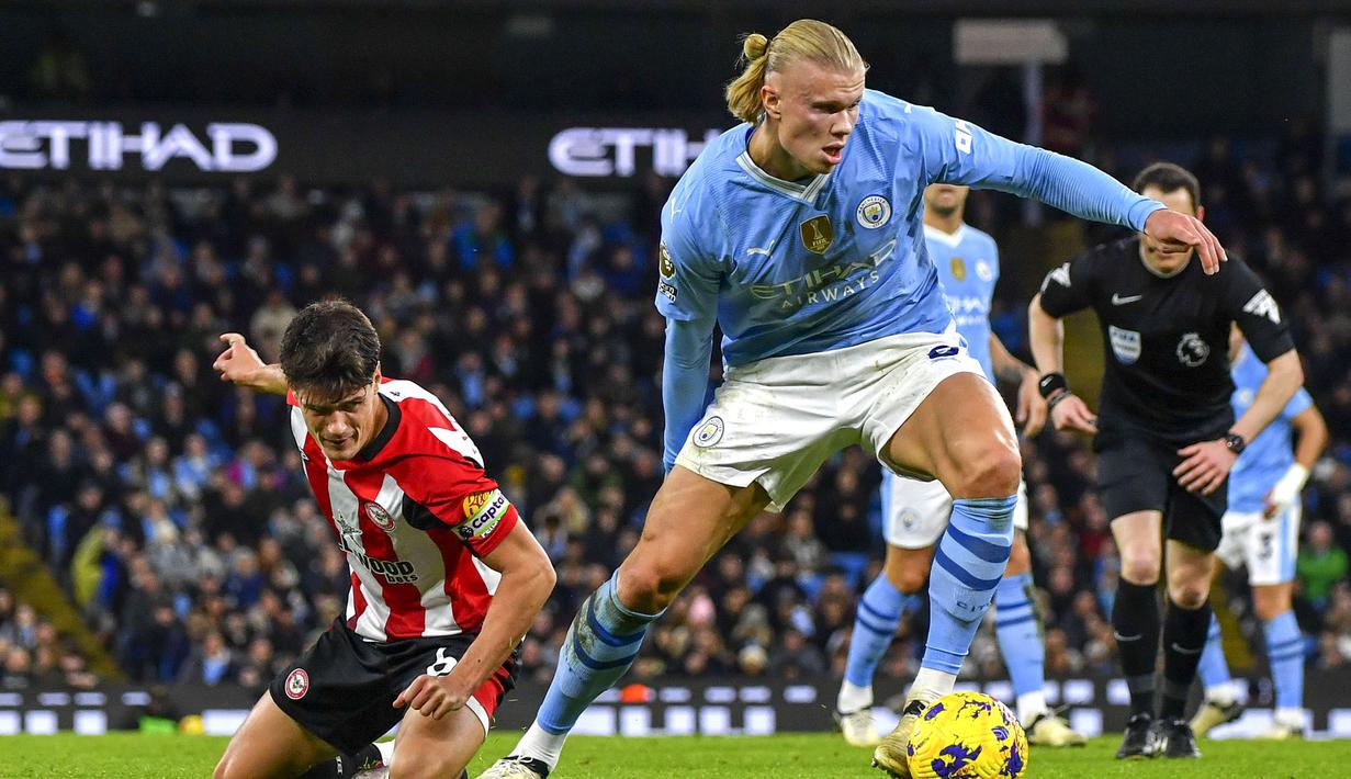 Pemain Manchester City, Erling Haaland (kanan) berusaha melewati pemain Brentford, Christian Noorgard pada laga lanjutan Liga Inggris 2023/2024 di Etihad Stadium, Manchester, Inggris, Rabu (21/02/2024) dini hari WIB. (AP Photo/Rui Vieira)