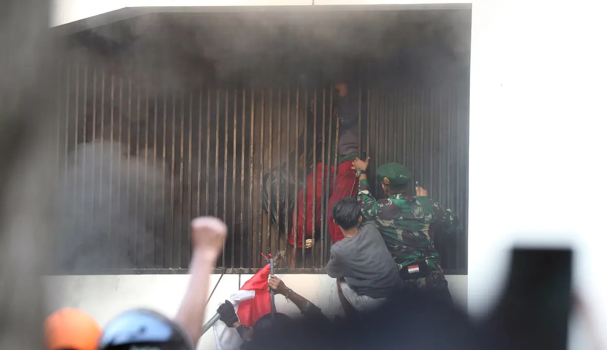 Di tengah kepulan asap hitam, muncul salah satu penghuni gedung yang sempat terjebak jeruji pagar di salah satu lantai. (Liputan6.com/Helmi Fithriansyah)