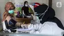 Petugas medis memeriksa kondisi tenaga kesehatan sebelum disuntik vaksin COVID-19 Sinovac di Puskesmas Palmerah, Jakarta, Kamis (28/1/2021). Pemberian vaksin COVID-19 tahap kedua dilaksanakan terhadap tenaga kesehatan mulai hari ini. (Liputan6.com/Johan Tallo)