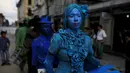 Kontestan berjalan saat  mengikuti kontes patung di pusat kota San Salvador , El Salvador, (18/6). Dengan mengecat seluruh tubuh mereka seperti patung, kita akan dibuat sulit membedakan mana patung asli dan tidak. (REUTERS / Jose Cabezas)