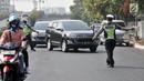 Polisi memberhentikan kendaraan saat hari pertama pemberlakuan perluasan sistem ganjil genap di Jalan Salemba Raya, Jakarta, Senin (9/9/2019). Polisi memberlakukan sanksi tilang terhadap pengendara yang melanggar aturan sistem ganjil genap. (merdeka.com/Iqbal Nugroho)