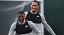 Keceriaan dua pemain asal Belanda Virgil van Dijk (kanan) dan Georginio Wijnaldum saat sesi latihan Liverpool di Melwood Training Ground, Liverpool, (3/4/2018). Liverpool akan menjamu Manchester City pada leg pertama Liga Champions. (AFP/Paul Ellis)