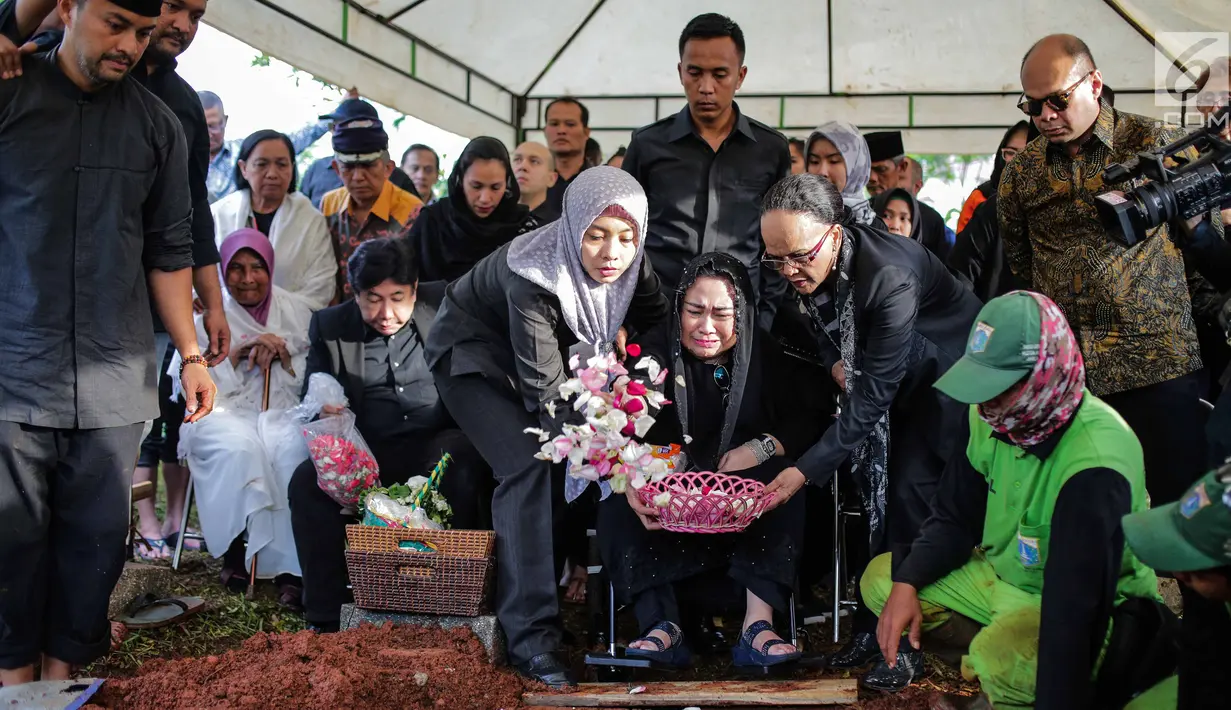 Rachmawati Soekarnoputri menaburkan bunga saat pemakaman sang suami Benny Soemarno  di TPU Karet Bivak, Jakarta, Senin (2/4). Benny Soemarno meninggal pada usia 68 tahun. (Liputan6.com/Faizal Fanani)