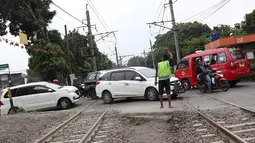 Kendaraan menyeberangi perlintasan kereta api di Lenteng Agung, Jakarta, Selasa (13/3). Untuk mengurai kemacetan imbas antrian kendaraan berputar balik di pintu kereta IISIP, Pemprov DKI berencana membangun flyover U-Turn. (Liputan6.com/Immanuel Antonius)