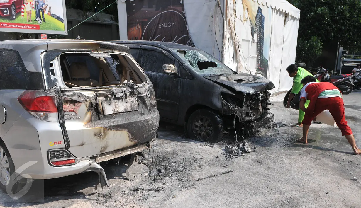 Petugas SPBU saat memadamkan sisa api kebakaran mobil di area SPBU Jalan Gatot Subroto, Jakarta, Selasa (1/9/2015). Sumber api diduga berasal dari sebuah drum yang berada di dekat tangki pengisian BBM di SPBU tersebut. (Liputan6.com/Herman Zakharia)
