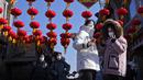 Perempuan bermasker mengambil foto saat pengunjung melewati lentera di gang perbelanjaan dekat Danau Houhai untuk merayakan Tahun Baru Imlek di Beijing, Senin, 16 Januari 2023. China untuk terus merilis informasi tentang gelombang infeksi COVID-19 setelah pemerintah mengumumkan hampir 60.000 kematian sejak awal Desember menyusul keluhan selama berminggu-minggu karena gagal memberi tahu dunia apa yang terjadi. (AP Photo/Andy Wong)