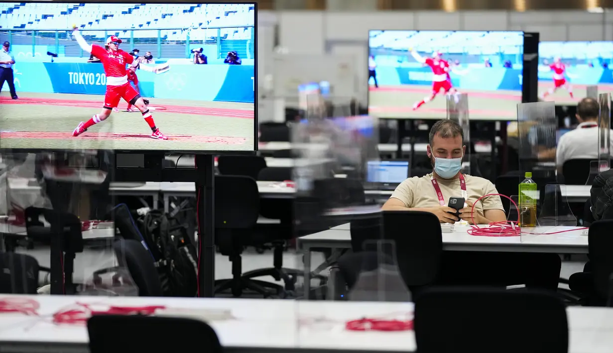 Seorang jurnalis duduk di area kerja media di Main Press Center (MPC) Olimpiade Tokyo 2020 di Tokyo pada Rabu (21/7/2021). Main Press Center mulai ramai dengan para jurnalis dari berbagai negara jelang pembukaan Olimpiade Tokyo 2020.  (AP Photo/Ashley Landis)