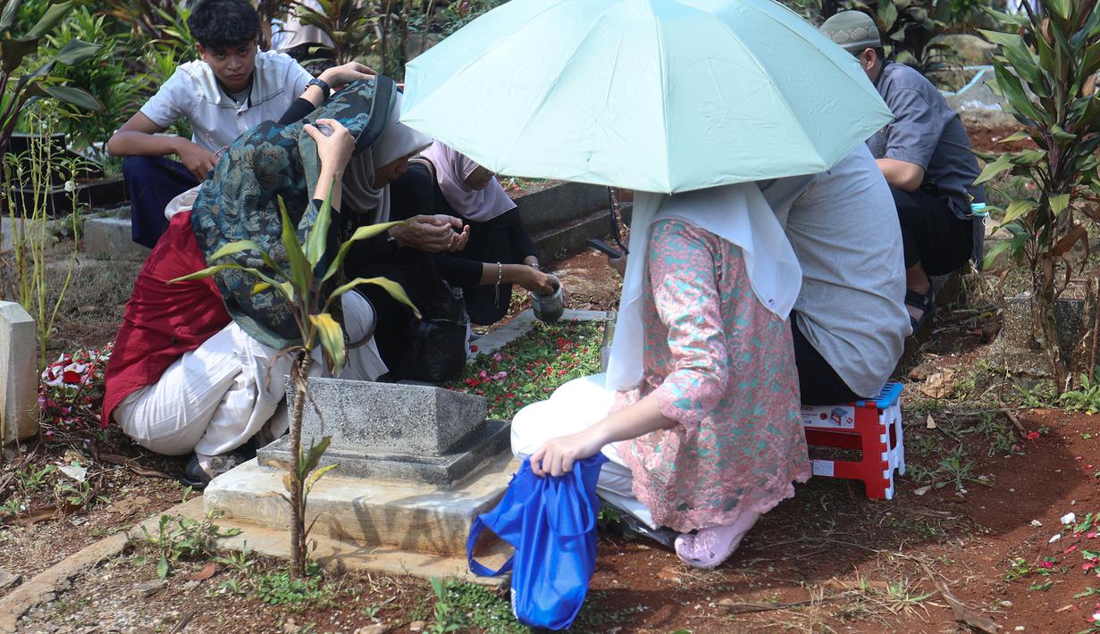 Suasana haru dan penuh khidmat terasa saat warga membersihkan makam, menaburkan bunga, serta memanjatkan doa. Tampak dalam foto, warga saat melakukan ziarah kubur usai melaksanakan salat Idulfitri 1447 Hijriah di salah satu Tempat Pemakaman Umum (TPU), Cibinong, Kabupaten Bogor, Jawa Barat, Sabtu (21/3/2026). (Kapanlagi.com/Budy Santoso)