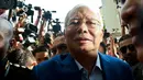 Mantan Perdana Menteri Najib Razak memasuki gedung kantor Komisi Anti-Korupsi Malaysia (MACC) untuk menjalani pemeriksaan di Putrajaya, Selasa (22/5). Kedatangan Najib ini memenuhi surat panggilan yang diantarkan ke rumahnya, pekan lalu. (AP/Sadiq Asyraf)