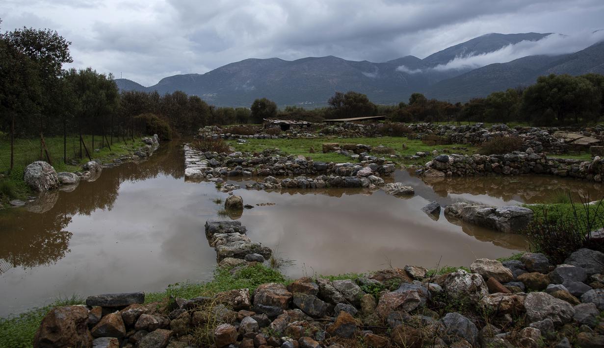 Air menutupi situs purbakala setelah hujan lebat di desa Malia, pulau Kreta, Yunani, Selasa (10/11/2020). Banjir besar di Pulau Kreta Yunani merusak jalan, membanjiri ratusan rumah, dan menyeret mobil ke laut di tengah hujan deras yang sedang berlangsung. (AP Photo/Harry Nakos)