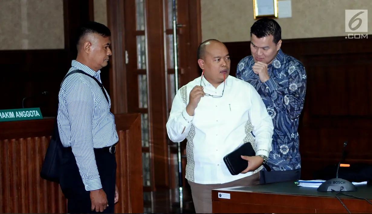Tersangka dugaan korupsi pengadaan E-KTP, Andi Agustinus/Andi Narogong (kanan) berbincang dengan kuasa hukumnya usai mengikuti sidang perdana di Pengadilan Tipikor, Jakarta, Senin (14/8). Sidang mendengarkan dakwaan JPU. (Liputan6.com/Helmi Fithriansyah)