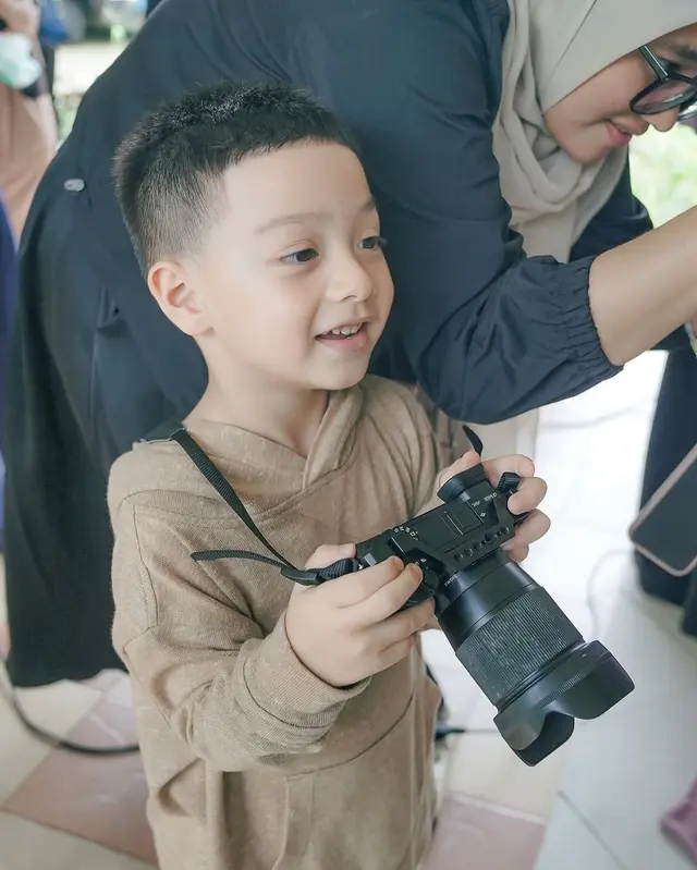 4. Air Rumi yang kini berusia empat tahun tampak bersenang-senang di lokasi pemotretan. Ia mencoba memainkan kamera layaknya sang fotografer.